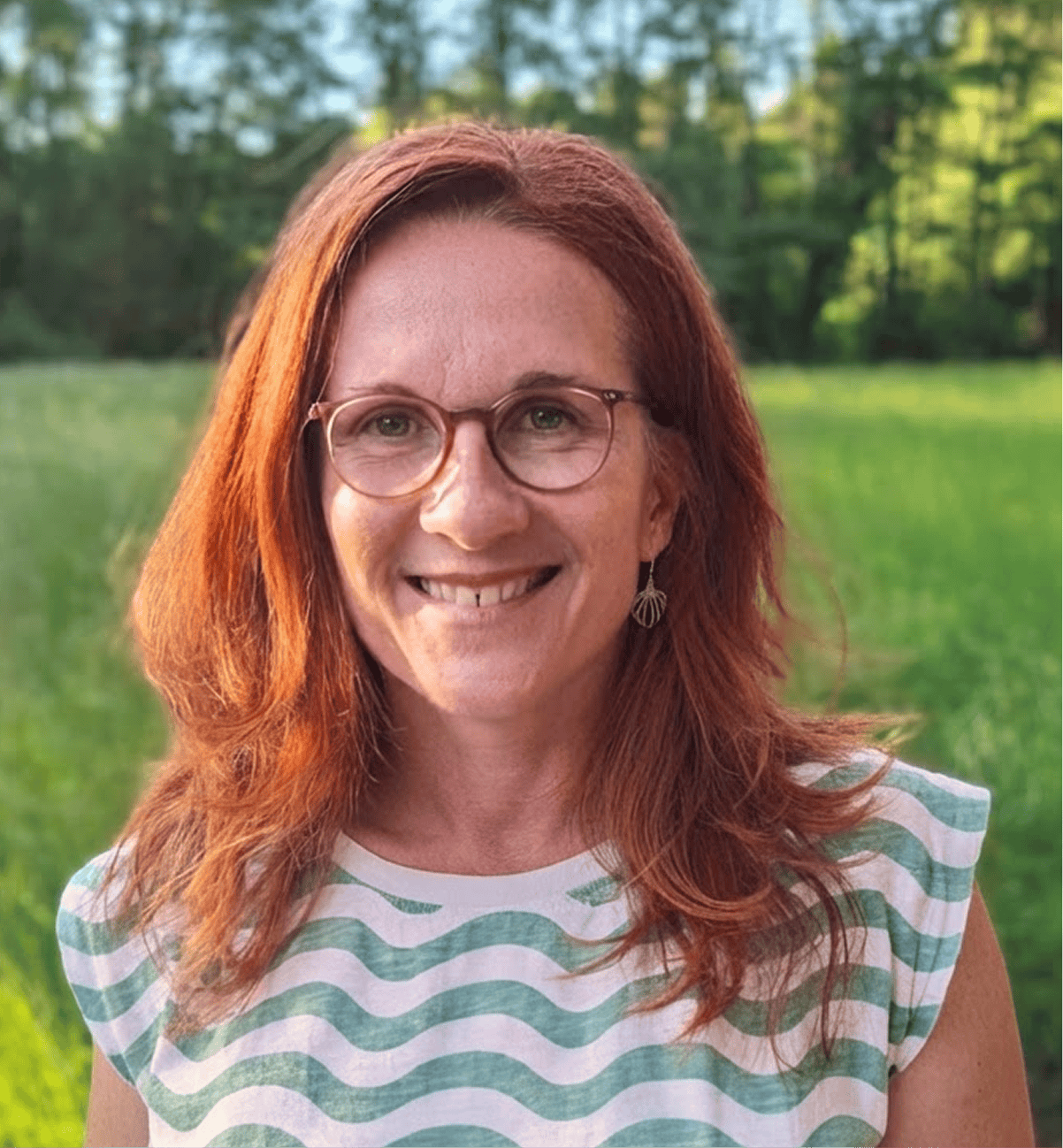 Profilbild Nadine Kuchar, Schulterlange rote Haare lächelt dich an.